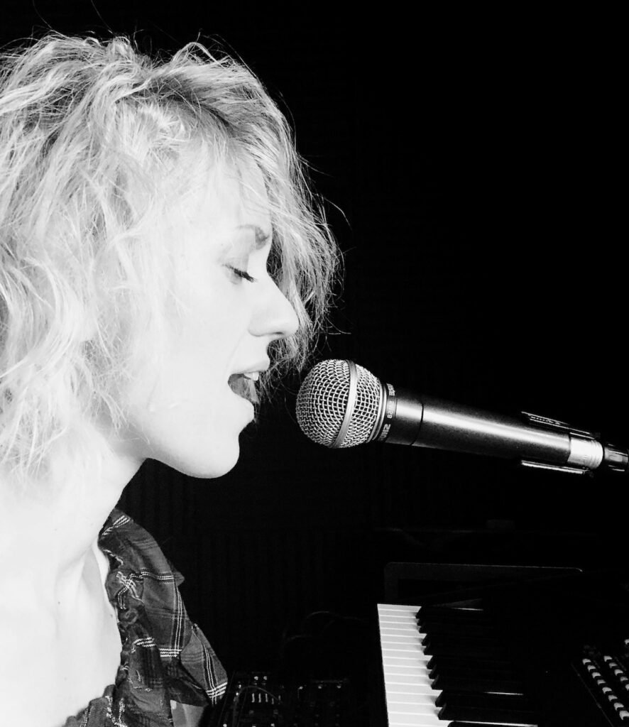 Monika Evans singing at the piano